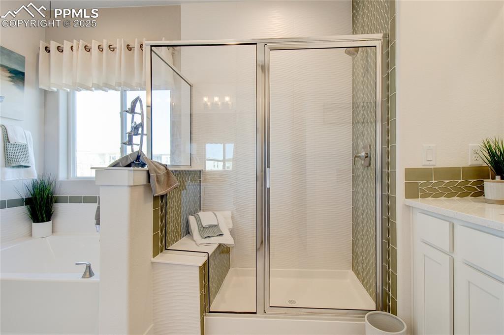 Image 20 of 27: Full bathroom featuring a stall shower, a bath, and vanity
