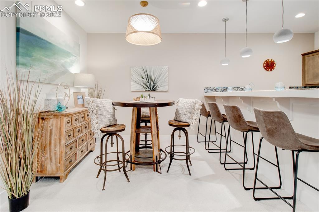 Image 24 of 27: Bar featuring hanging light fixtures and recessed lighting