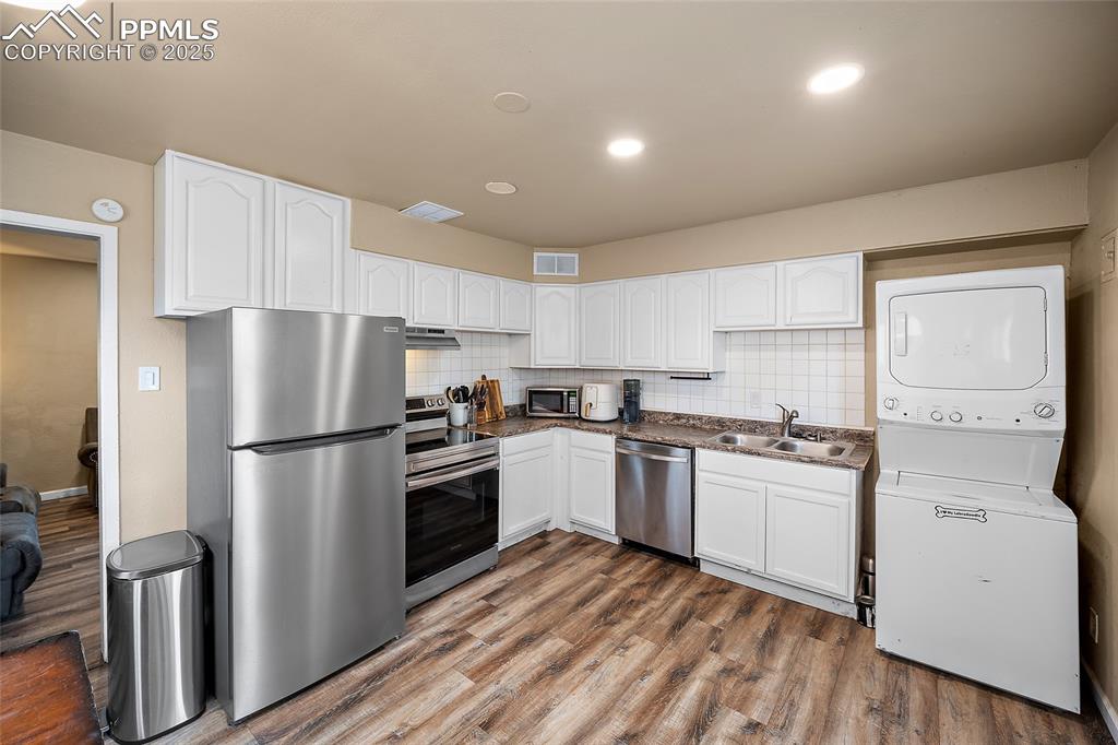 Image 3 of 12: Kitchen featuring stainless steel appliances, stacked washing machine and d