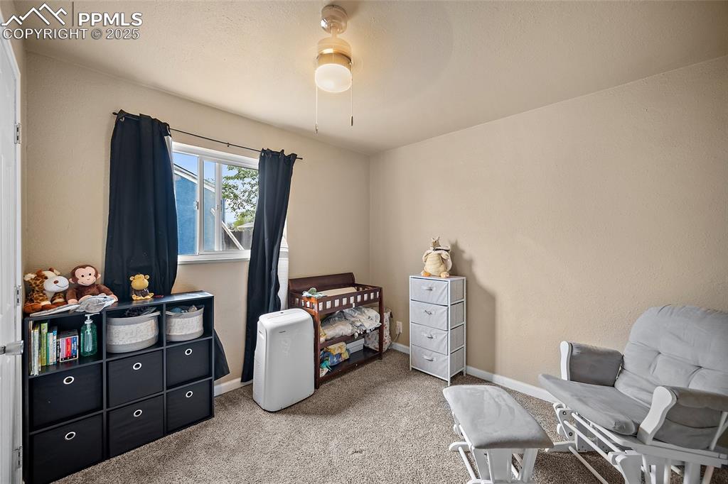 Image 7 of 12: Carpeted bedroom featuring baseboards and a ceiling fan