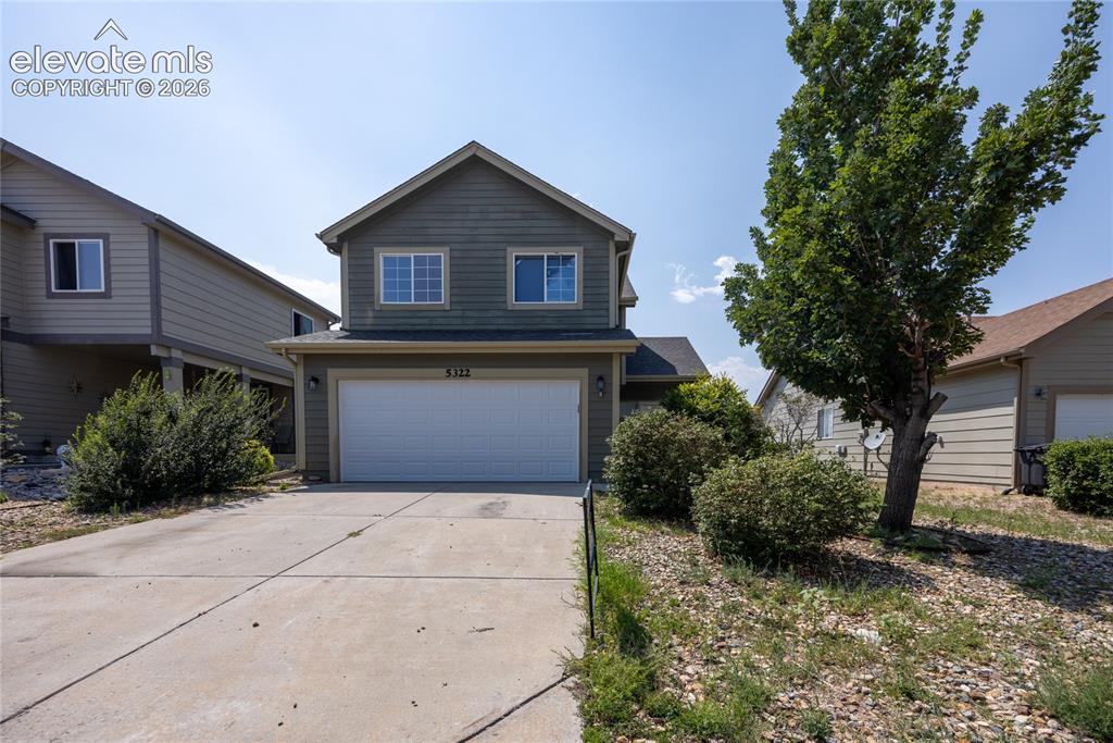 Image 1 of 31: Two-story residence featuring a two-car garage, concrete driveway, and matu