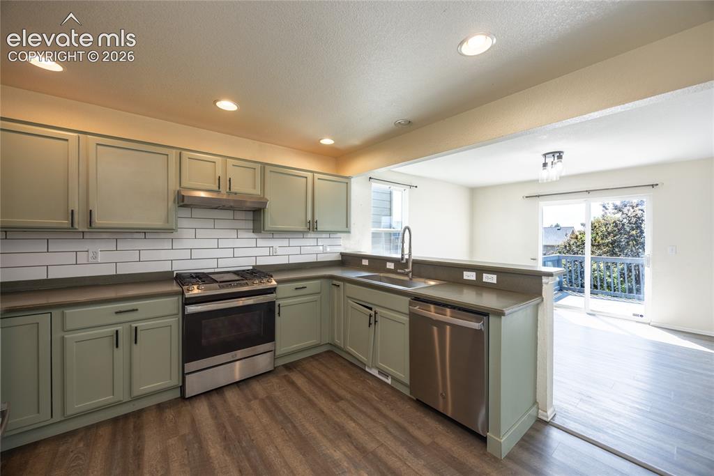 Image 10 of 31: Kitchen featuring wood-finish flooring, recessed lighting, and stainless st