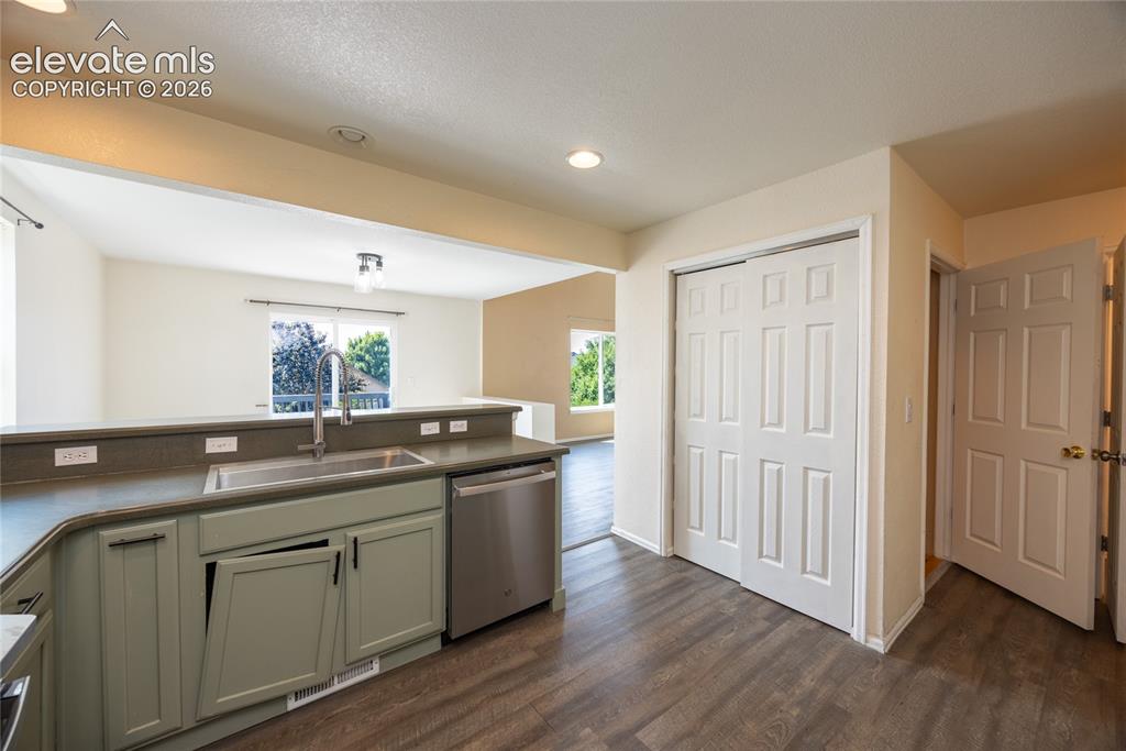 Image 11 of 31: Kitchen featuring wood-finish flooring, recessed lighting, stainless steel