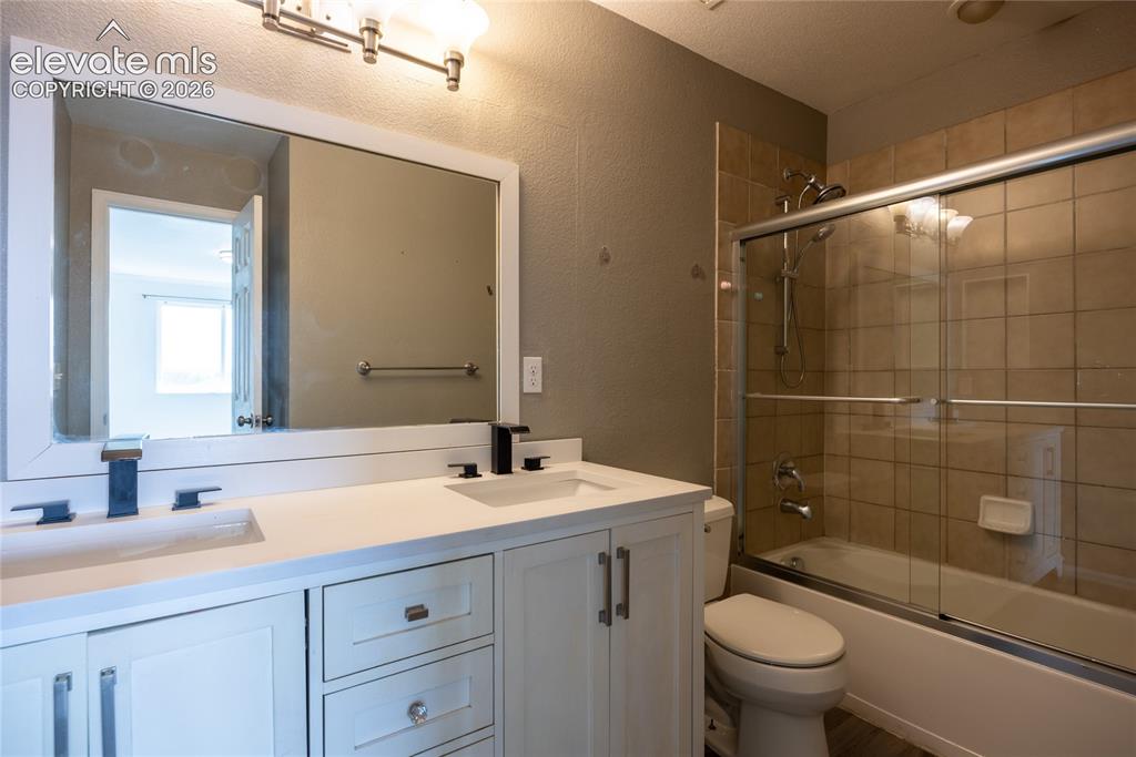 Image 16 of 31: Dual vanity with integrated sinks and black-finish faucets, white shaker-st