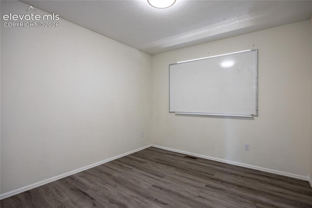 Image 19 of 31: Recessed lighting illuminating the room with wood-finish flooring