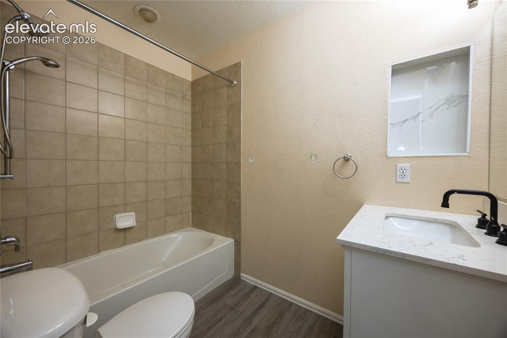 Image 21 of 31: Full bathroom featuring a soaking tub with tile surround and overhead showe