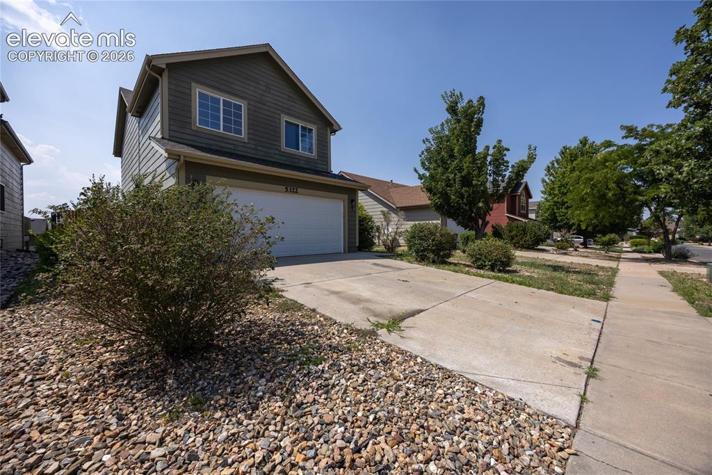 Image 4 of 31: Two-story residence with horizontal siding, an attached garage, and a concr