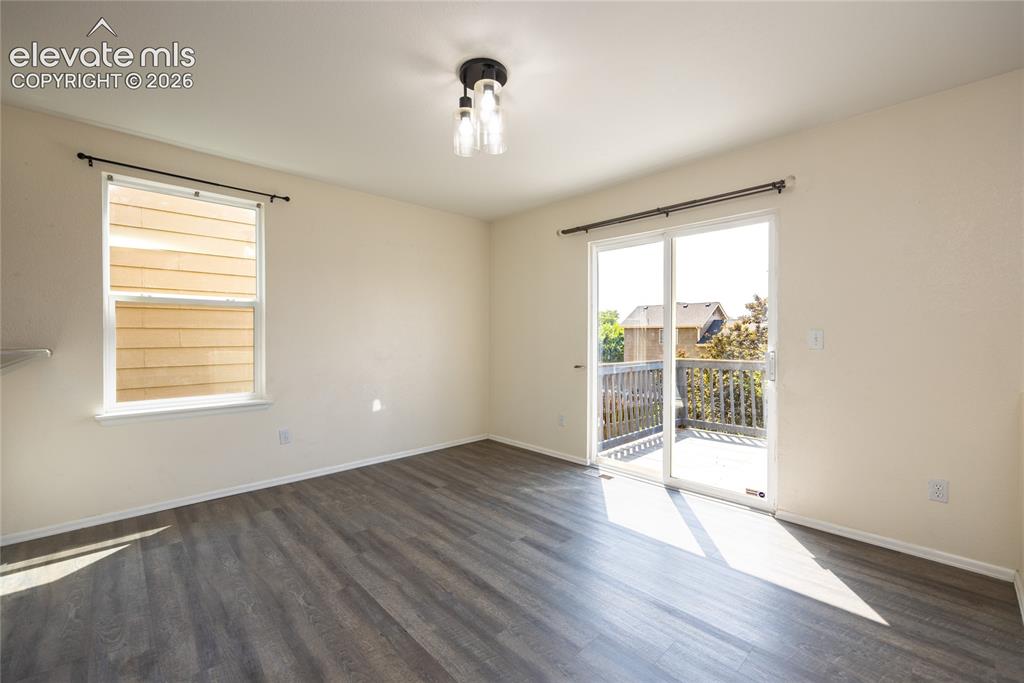 Image 7 of 31: Wood-finish flooring, sliding glass door to exterior deck, and a contempora