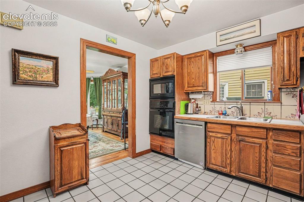 Image 10 of 27: Kitchen featuring wood cabinetry, integrated double wall ovens, a stainless