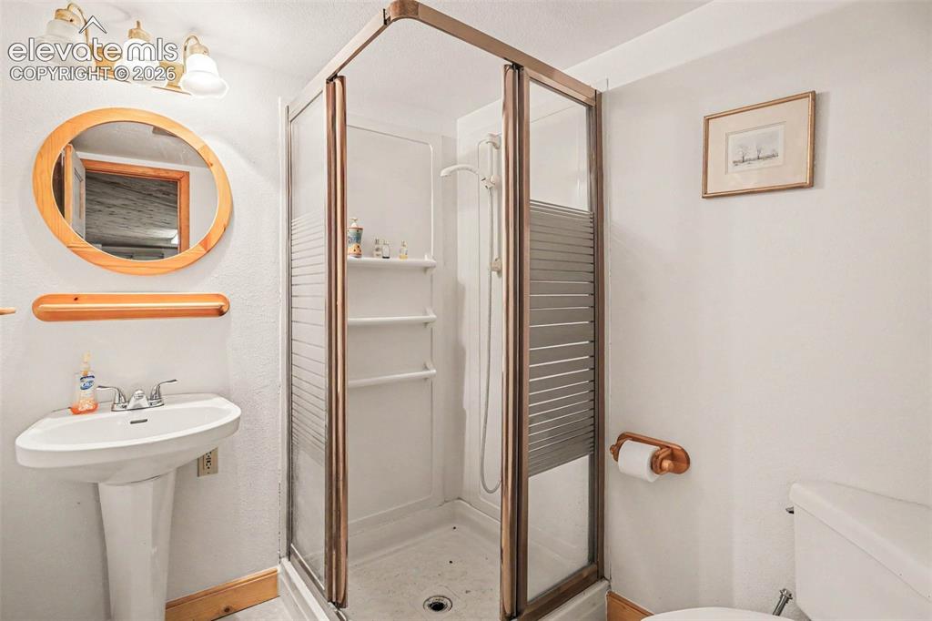 Image 18 of 27: Enclosed shower with bronze-finish frame and frosted glass panels