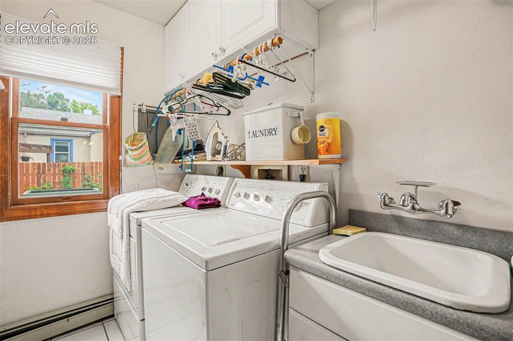 Image 19 of 27: Dedicated laundry room featuring a utility sink with a wall-mounted faucet,