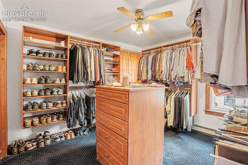 Image 20 of 27: Custom walk-in closet system created from a former bedroom and easily conve