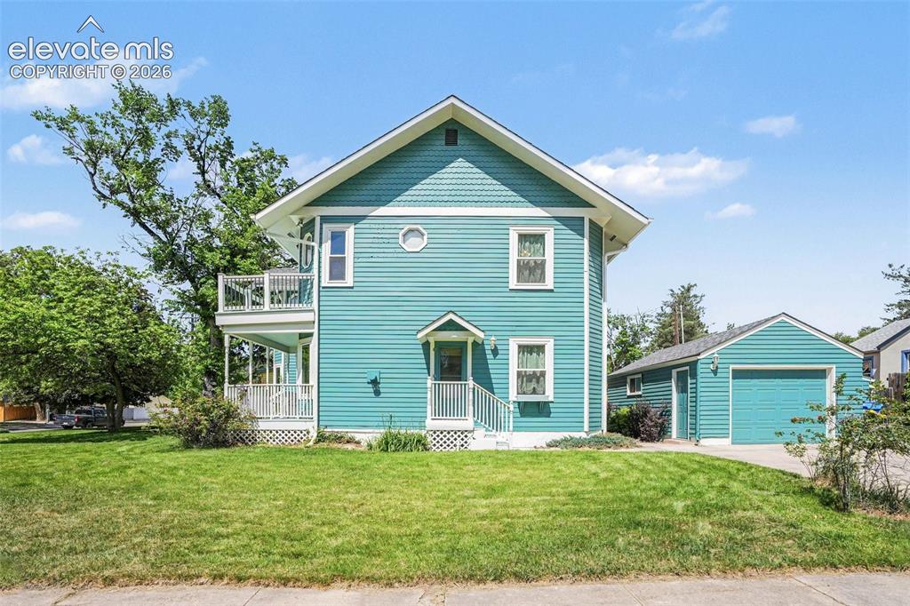 Image 25 of 27: This charming two-story residence features eye-catching teal siding accente