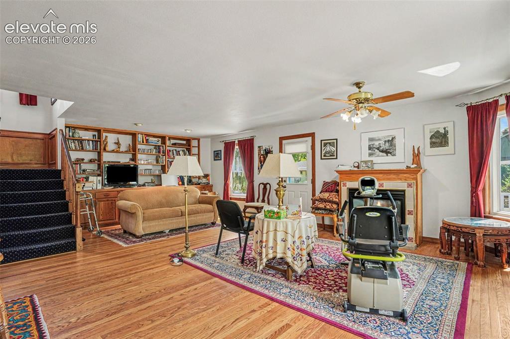 Image 5 of 27: The spacious living area features beautiful hardwood flooring, a cozy firep