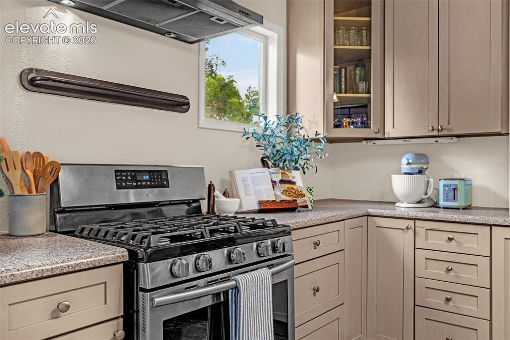 Image 11 of 33: Stainless steel gas range with coordinating ventilation hood, built-in cabi