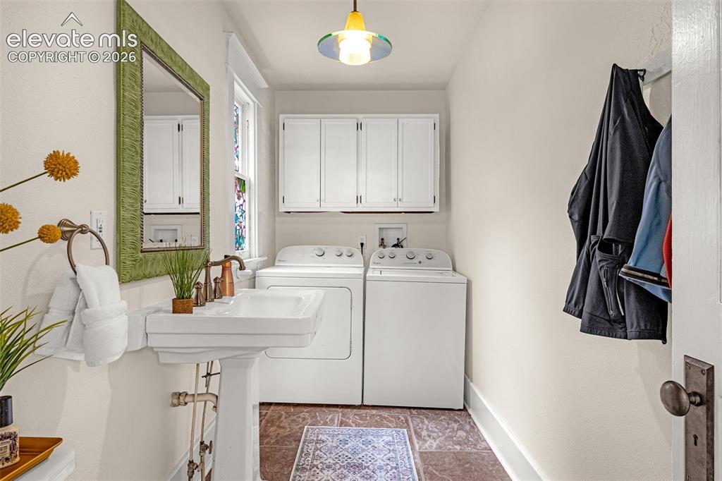 Image 14 of 33: Bright partial bath and  laundry room featuring dual white front-load appli