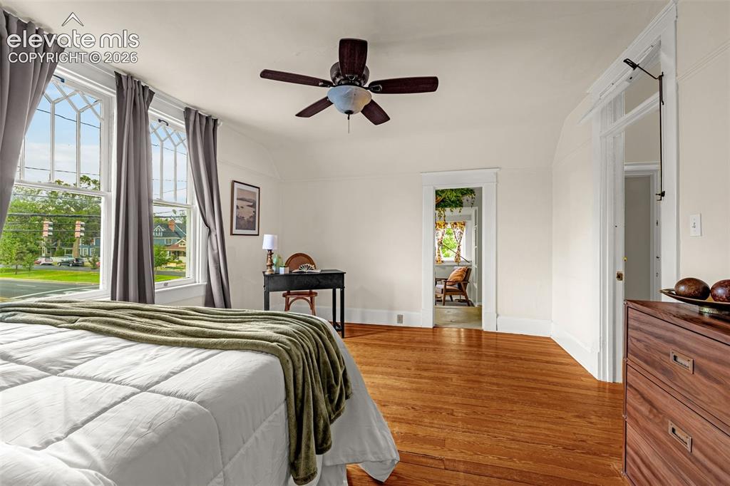 Image 19 of 33: Hardwood flooring, painted walls, ceiling fan, white trim, and a built-in d