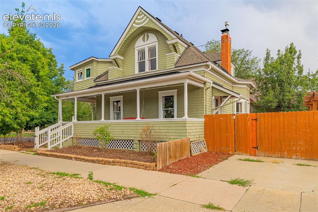 Image 25 of 33: Classic Victorian-style residence featuring a wraparound front porch with d