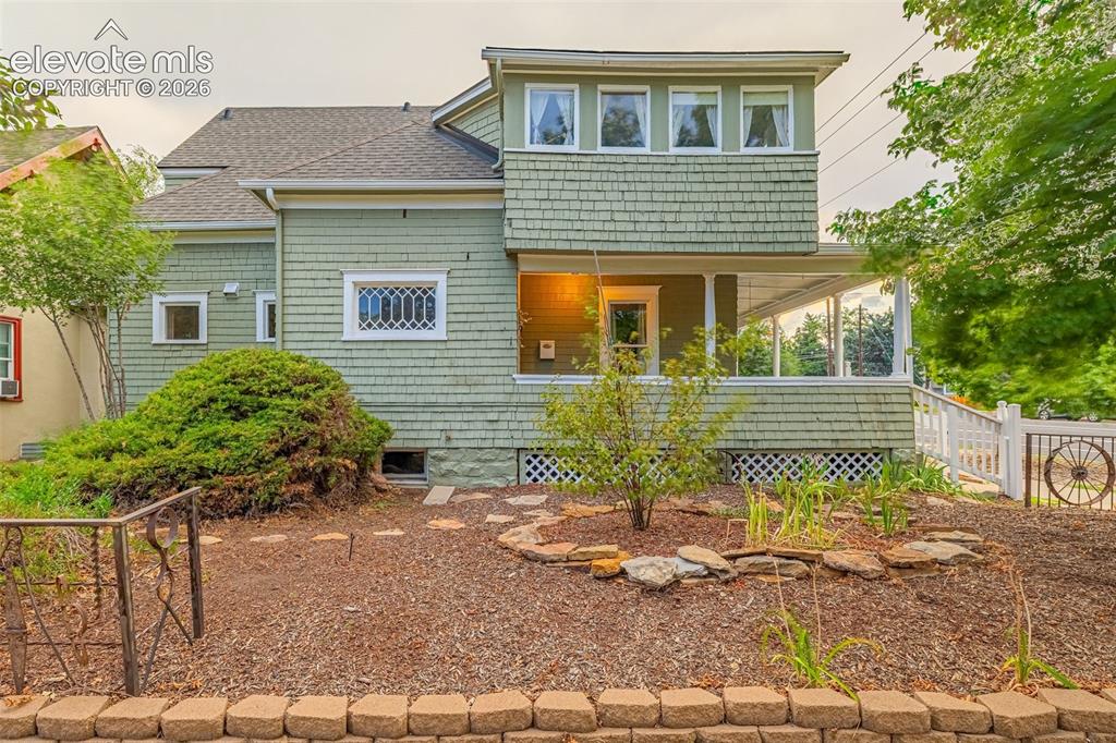 Image 26 of 33: Two-story exterior featuring a covered porch, shingle siding, a partial sto