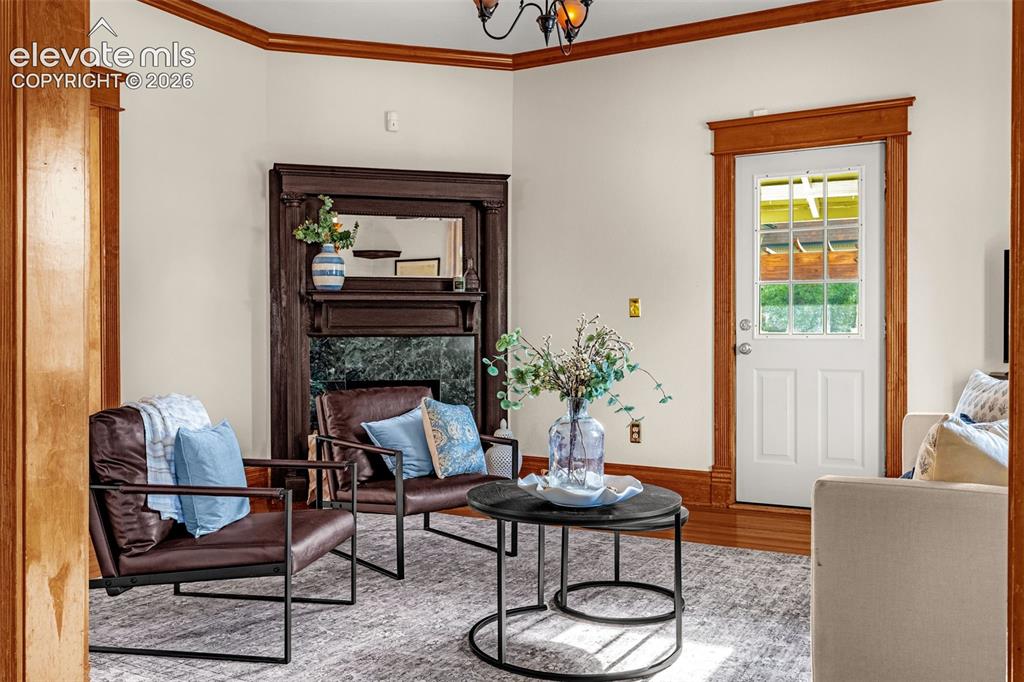 Image 6 of 33: Main living with fireplace, entry to backyard, detailed wood trim