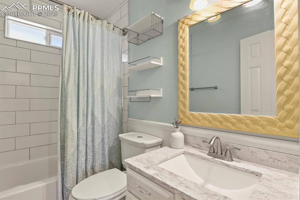 Image 17 of 39: Bathroom featuring vanity, shower / bath combo with shower curtain, and wai