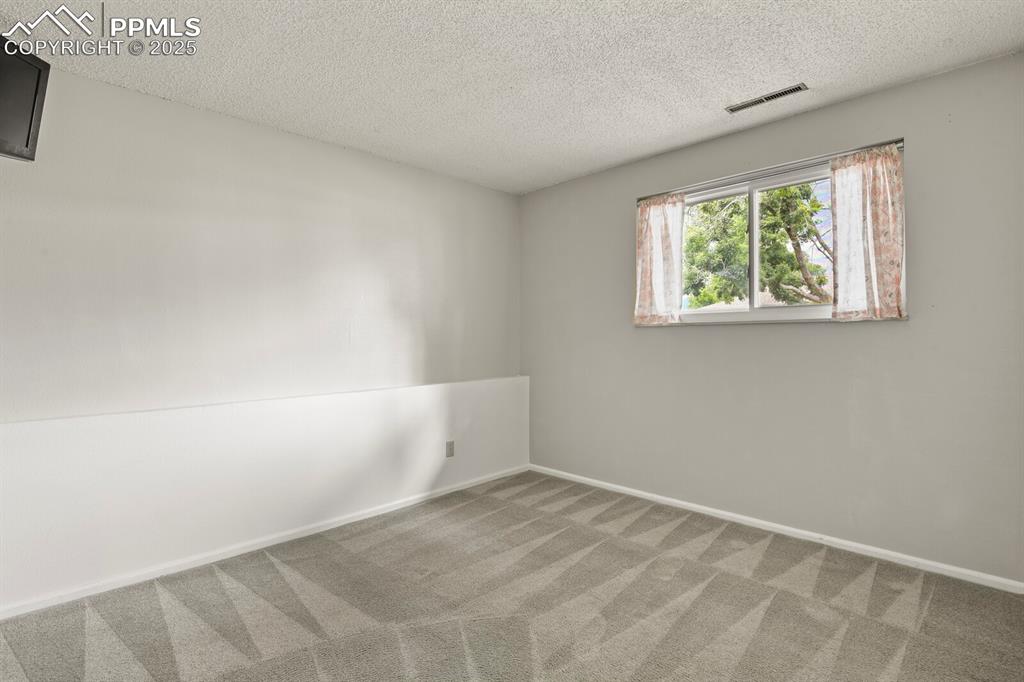 Image 25 of 39: Carpeted spare room featuring a textured ceiling and baseboards