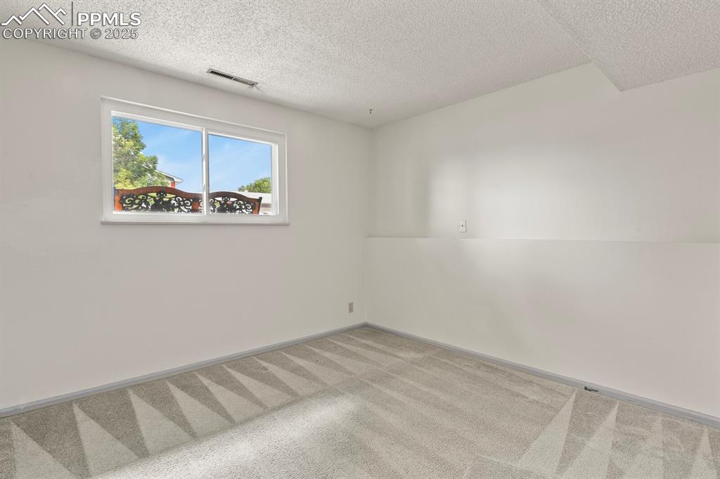 Image 28 of 39: Bedroom featuring a textured ceiling and carpet floors
