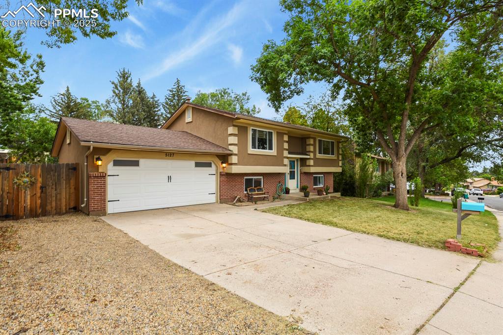 Image 3 of 39: Split foyer home featuring brick siding, driveway, an attached garage, and