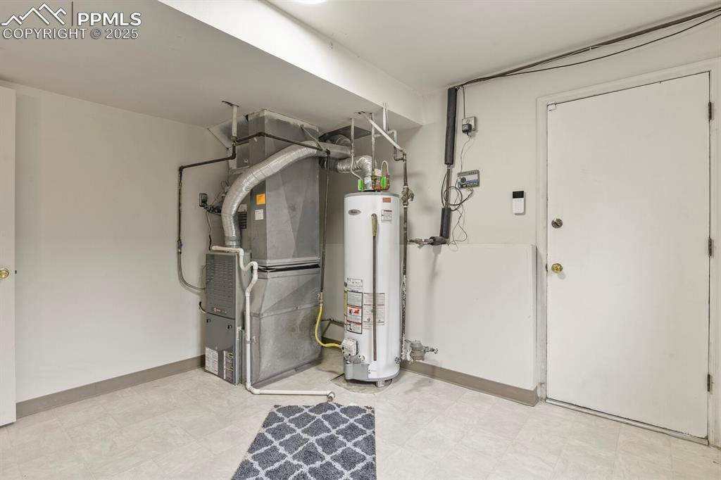 Image 30 of 39: Utility room with heating unit and gas water heater
