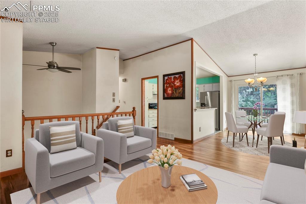Image 4 of 39: Virtually Staged Living-Dining room with a textured ceiling, lofted ceilin