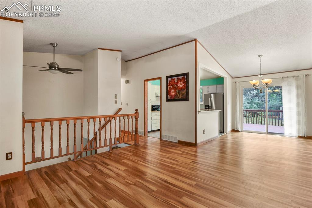Image 5 of 39: Living room and kitchen featuring wood finished floors, a textured ceiling,