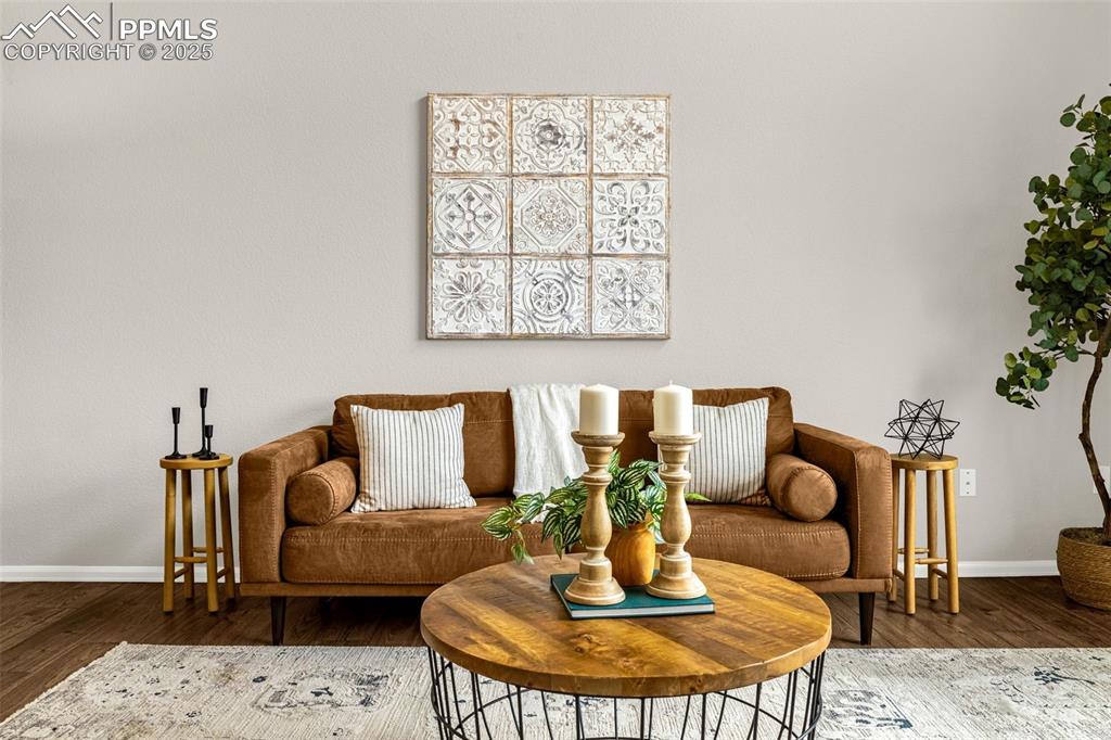 Image 11 of 39: Living area with baseboards and wood finished floors