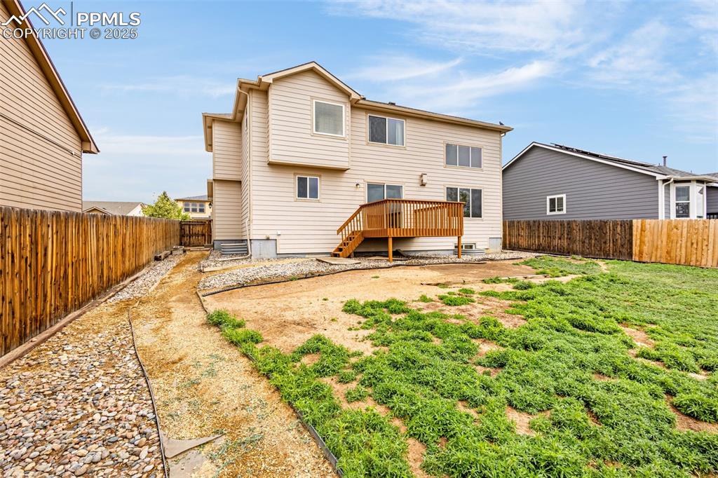 Image 3 of 39: Rear view of property featuring a fenced backyard and a wooden deck