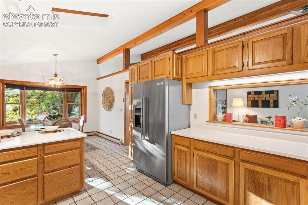 Image 11 of 47: Kitchen featuring wood cabinetry, stainless steel refrigerator, white count