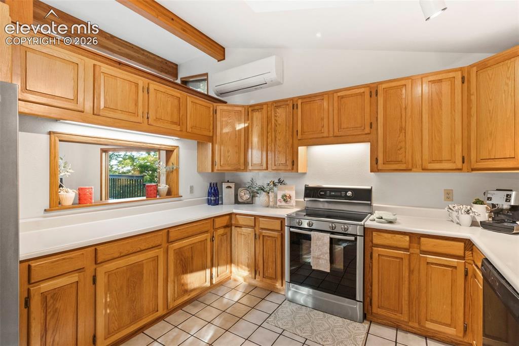 Image 12 of 47: Kitchen featuring natural wood cabinetry, white countertops, ceramic tile f