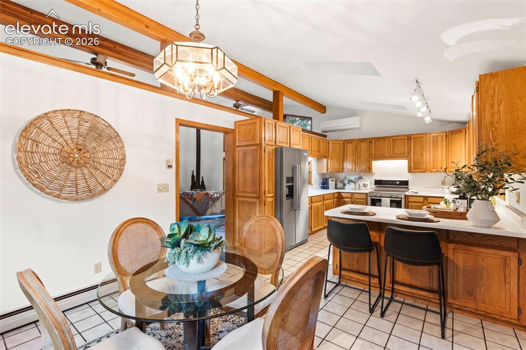 Image 16 of 47: Vaulted ceiling with exposed wood beams, tiled flooring, cabinetry with woo