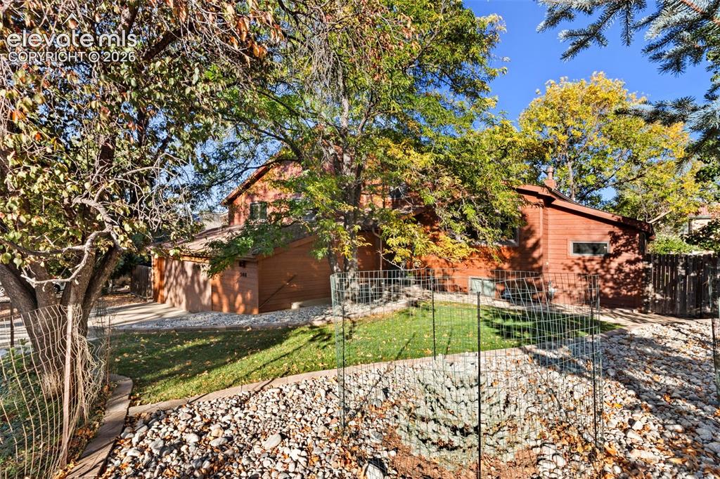 Image 2 of 47: Horizontal wood-sided exterior, attached multi-car garage, manicured lawn, 