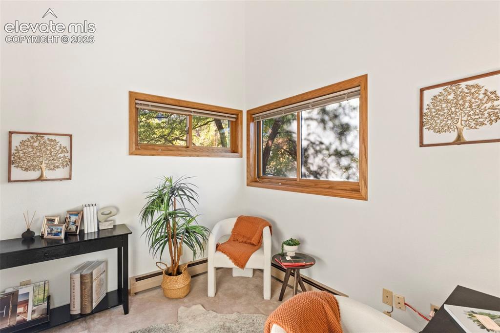 Image 22 of 47: High-ceiling room featuring white walls and two sliding windows framed in n