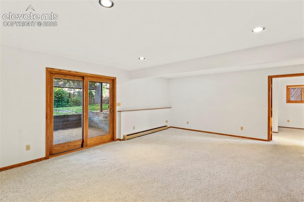 Image 26 of 47: Neutral-toned carpeted interior featuring recessed lighting, natural wood-f