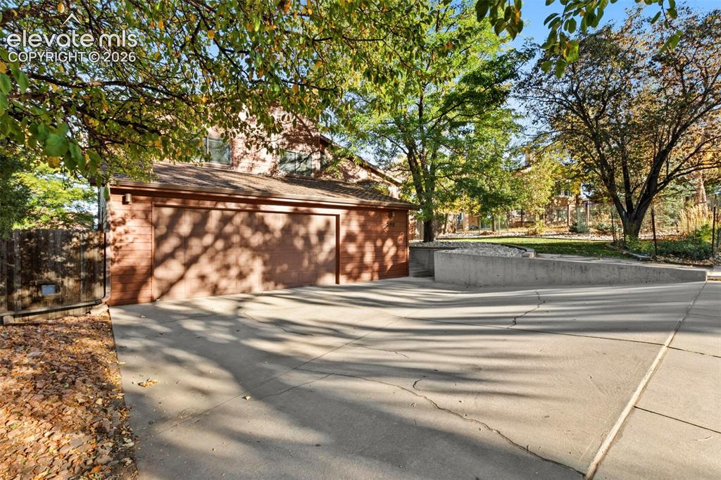 Image 3 of 47: Brick exterior finish, attached multi-car garage, concrete driveway, and co