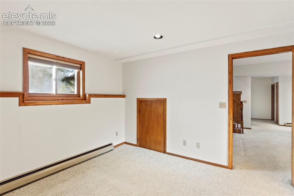 Image 30 of 47: Room featuring neutral wall-to-wall carpeting, wood trim casing around the