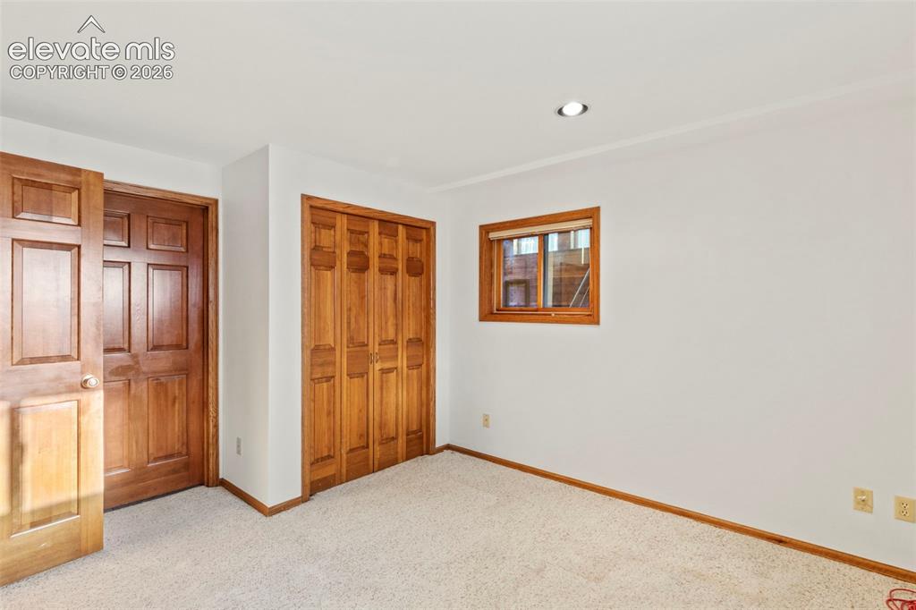 Image 31 of 47: Room featuring neutral carpeting, six-panel wood-finish door, bi-fold woode