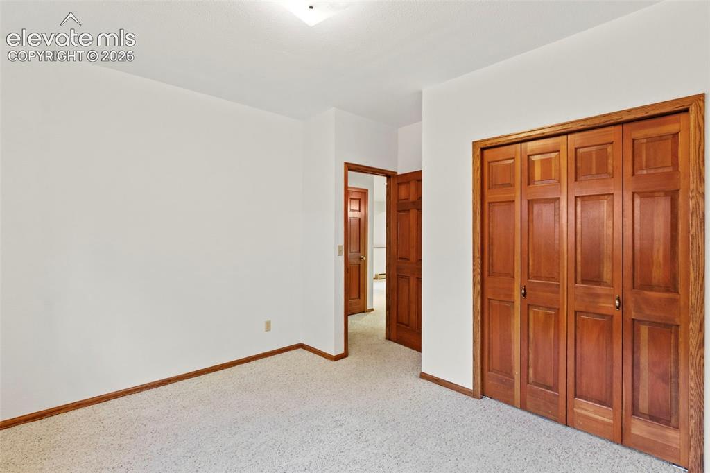 Image 33 of 47: Neutral-toned carpeting, wood-finish interior doors with six-panel detailin