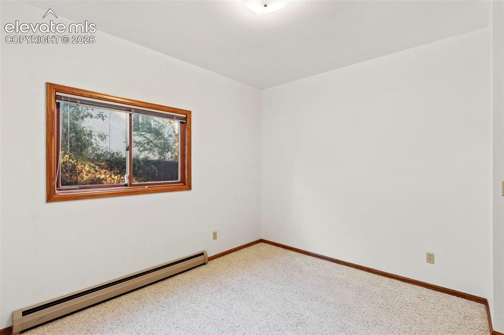Image 34 of 47: Interior room featuring neutral wall paint, carpeting, a window with wood-f