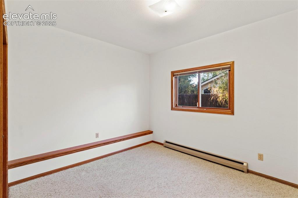 Image 35 of 47: Neutral-toned carpeted room featuring a built-in wood-trim ledge, a sliding