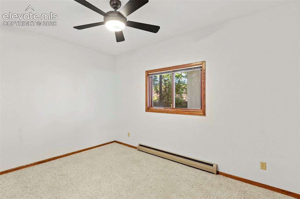 Image 39 of 47: Neutral-toned interior space featuring carpeting, a multi-blade ceiling fan