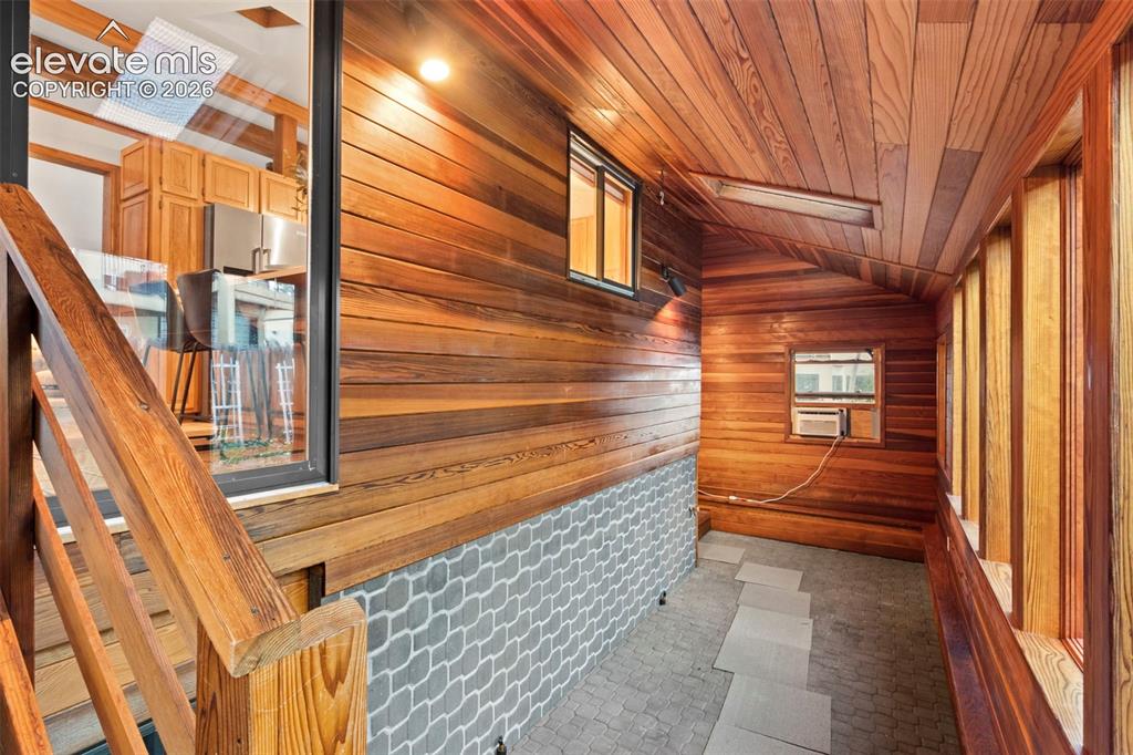 Image 41 of 47: Enclosed space featuring natural wood-paneled walls and ceiling, stone-patt