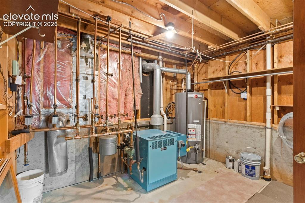Image 43 of 47: Utility space featuring a boiler, a vertical hot water tank, exposed copper