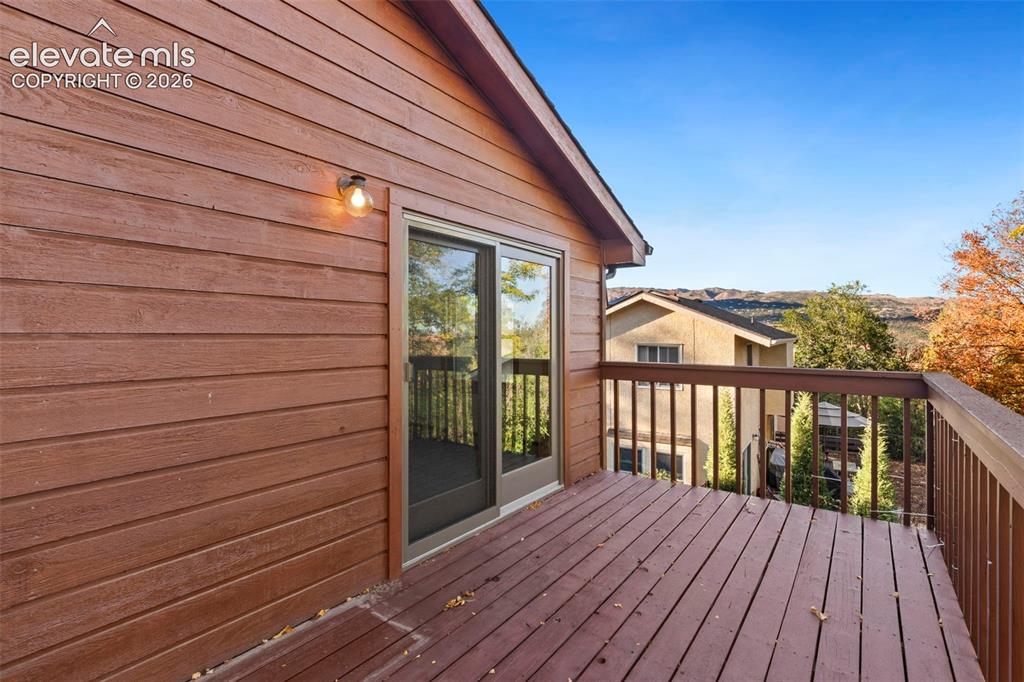 Image 44 of 47: Elevated wooden deck featuring horizontal lap siding, sliding glass doors, 