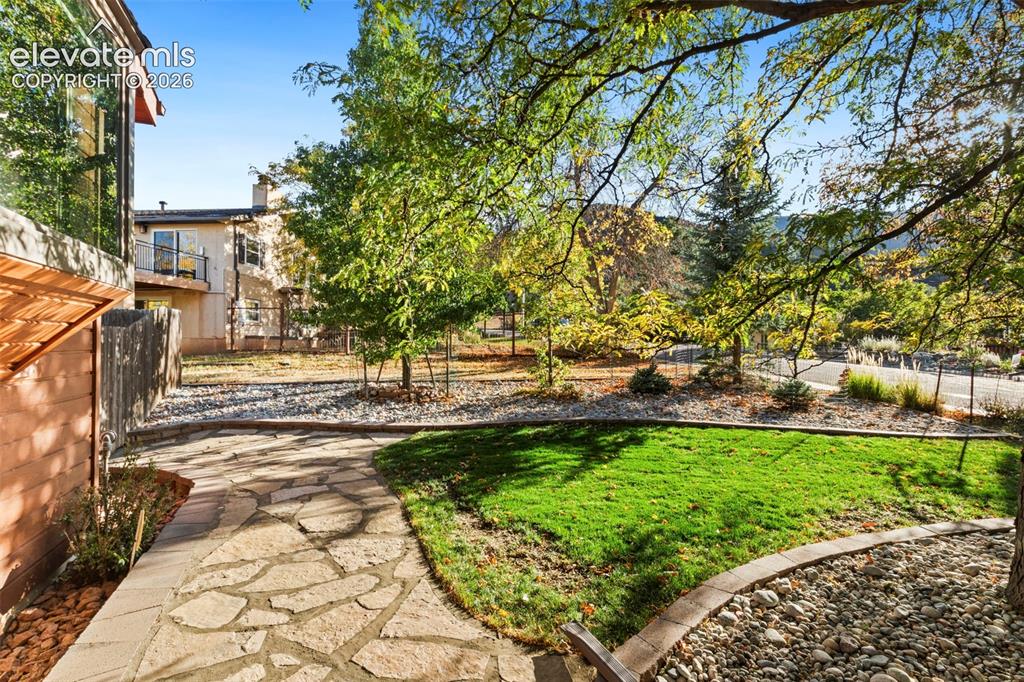 Image 47 of 47: Flagstone patio featuring a grass lawn, decorative stone ground cover, and 